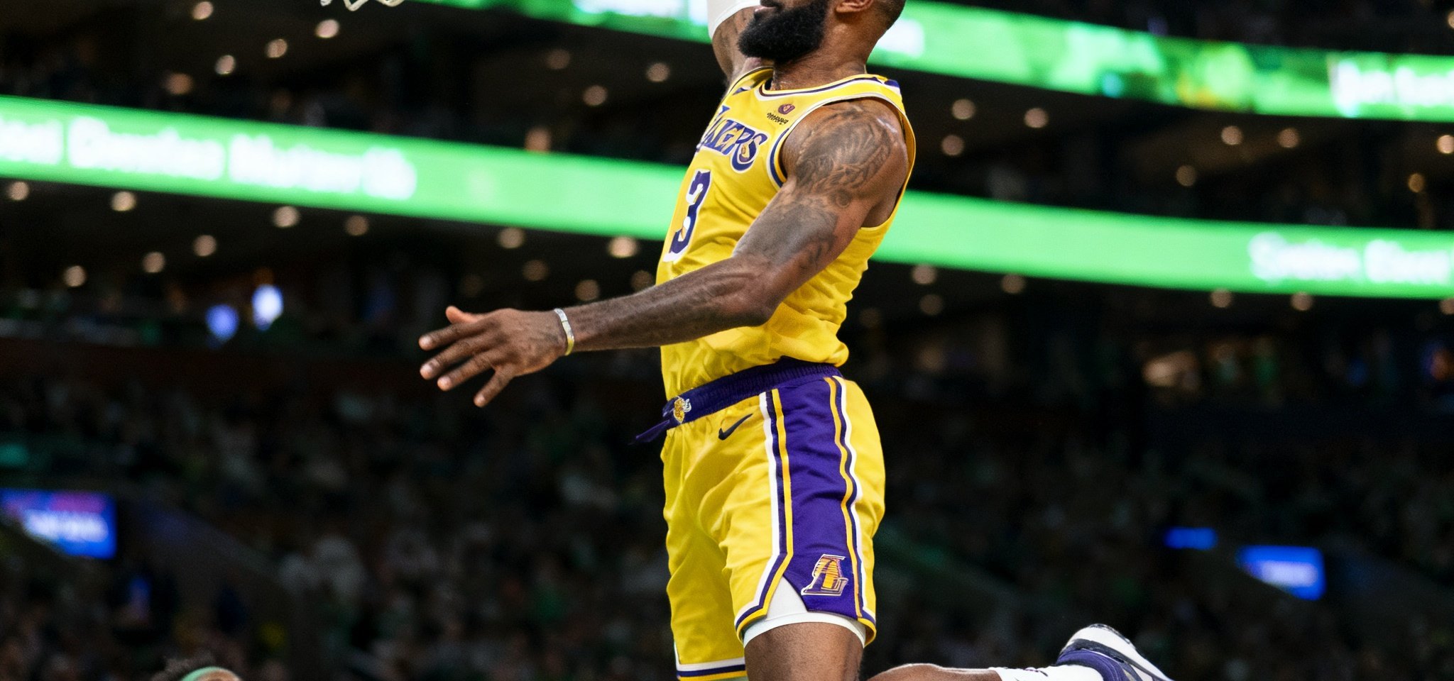 NBA季后赛高清直播，洛杉矶湖人队与波士顿凯尔特人队在球场激烈对决，球员飞身扣篮瞬间捕捉